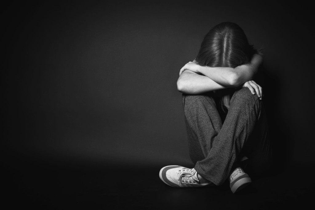 woman in depression and despair crying on black dark